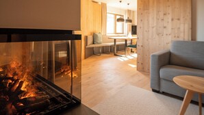 Een moderne woonkamer met een open haard, een bank en een eethoek.