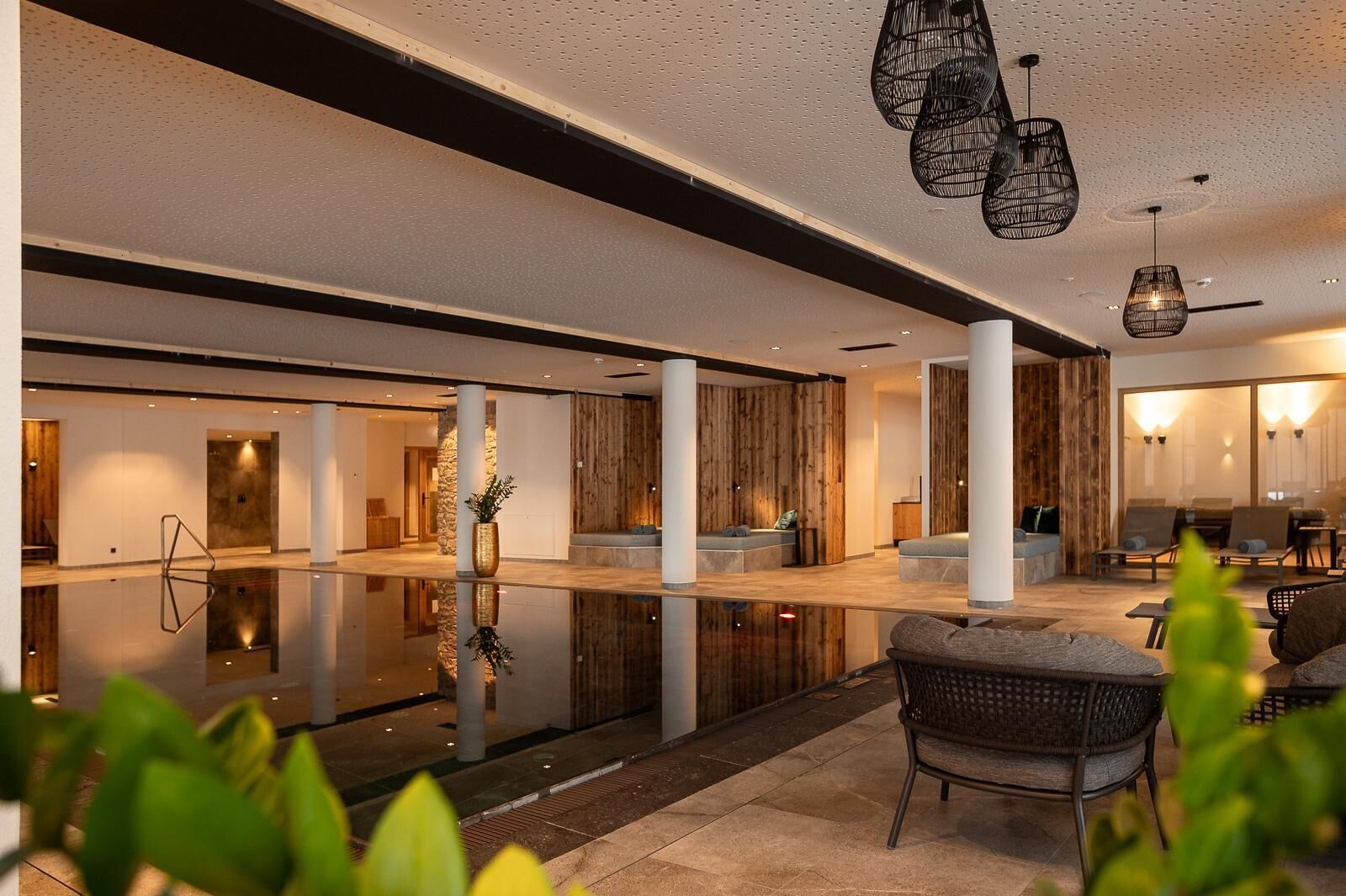 A spacious lobby with a reflective floor, seating areas, and modern lighting fixtures.