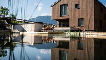 Un edificio moderno de madera con una piscina delantera.
