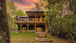 A modern wooden cabin with a stone staircase leading to the entrance, surrounded by trees. - In Boone! Hot Tub - Firepit - Sleeps 10 - Wifi (Boone)