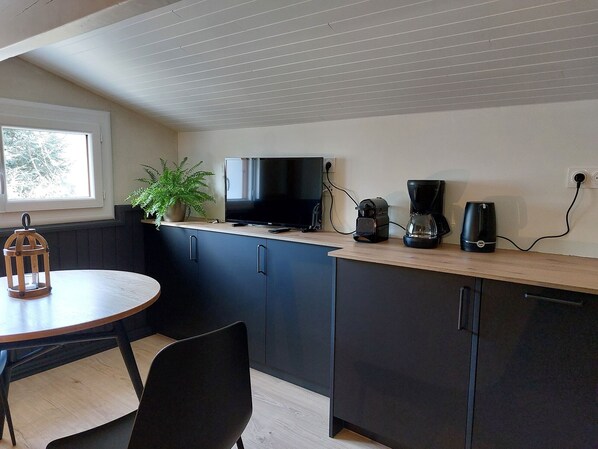 A compact kitchen with a wooden countertop, a TV, a coffee maker, and a potted plant. - T2 Très Cocooning Dans un Chalet Traditionnel Entièrement Rénové (SAINT LARY SOULAN)