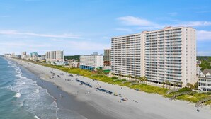 A beachfront hotel with multiple floors, a sandy beach, and a clear view of the ocean. - Oceanfront Crescent Beach 1K 2Q SS | 4th Floor Unit 409 (North Myrtle Beach)