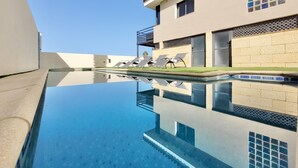 A swimming pool with a clear reflection, a modern building with a balcony, and a view of the sky. - Villa with Privacy and Spectacular Views of Teide, Sea, Orotava Valley (La Orotava)