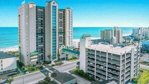 A high-rise hotel with multiple floors, a parking garage, and a view of the beach. - Oceanfront Windy Hill Beach 1K 3Q (North Myrtle Beach)