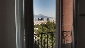 A view from a balcony with a metal railing, overlooking a cityscape with buildings and a mountain in the distance. - Panoramic apartment with large roof terrace in Naples, view of harbor, Vesuvius (Neapel)
