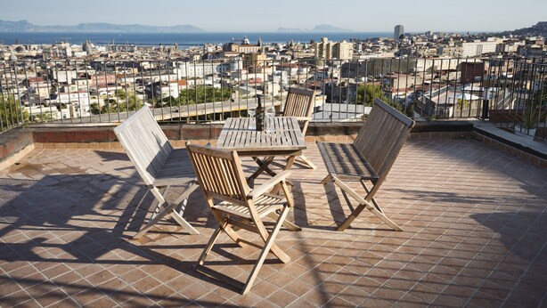 A rooftop terrace with a table and chairs, offering a panoramic city view. - Panoramic apartment with large roof terrace in Naples, view of harbor, Vesuvius (Neapel)