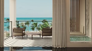 A balcony with a view of the ocean, two chairs, a small table, and a jacuzzi. - Excellence Coral Playa Mujeres - Adults Only All Inclusive (Punta Sam)