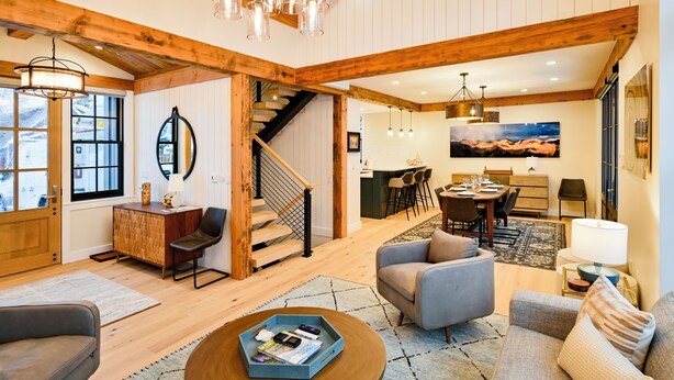 Un vaste espace de vie comprenant un escalier en bois, un coin repas et une cuisine.