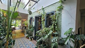 Un conservatorio con diversas plantas, un suelo estampado y vistas al espacio interior.