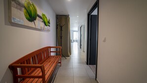 Un passadís amb una banca de fusta, un quadre de bananes i una perxa per abrigalls.
