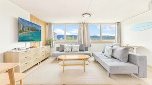 Una sala de estar moderna con un sofá, una mesa de centro, un televisor y un mueble de madera.