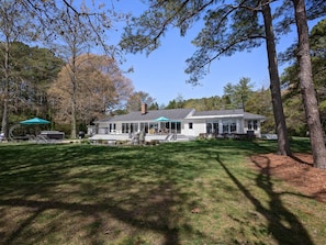 A house with a covered porch, a barbecue area, and a lawn.