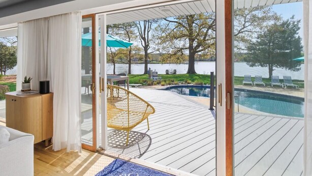 Un intérieur moderne avec une porte-fenêtre coulissante donnant sur une terrasse extérieure avec une piscine.