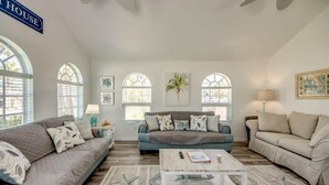 Ein geräumiges Wohnzimmer mit einem großen Fenster, einem Couchtisch und zwei Sofas.