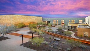 A modern building with a stone facade and a courtyard with landscaping. - 2BR Central Phoenix - Backyard - Near Sky Harbor (Phoenix)