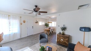 A spacious living room with a ceiling fan, a dining area with a table and chairs, and a cozy seating area with a sofa and armchairs. - 2BR Central Phoenix - Backyard - Near Sky Harbor (Phoenix)