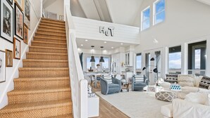 A spacious living area with a staircase, a kitchen, and a dining area. - #Beach Please - Amazing Views From All Directions - Close to the beach (Crystal Beach)