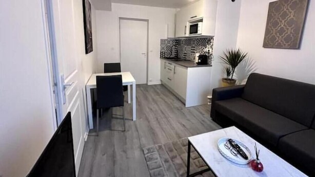 Un espace de vie compact comprenant un coin repas, une kitchenette et un canapé.