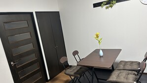 En matplats med ett bord, stolar och en vas med blommor.