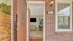 Ein Ziegelhaus mit Holztür, einer Nummer 311 und einem Fenster mit Rollläden.
