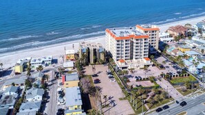 A coastal hotel with multiple floors, a parking lot, and a beach view. - Elevated Ground Level Direct Gulf Front 2 Bedroom/2 Bath Condo (Redington Shores)