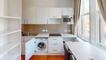 Een koelkast, een magnetron, kookgerei, borden en bestek