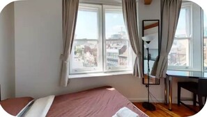 A bedroom with a bed, a desk, and a window with curtains. - Heart of Nottingham-Great City Views (Nottingham)