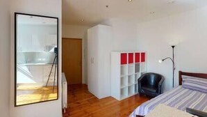 A room with a bed, a chair, a desk, and a wardrobe. - Quieter Studio for City Centre Location (Nottingham)