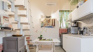 Une cuisine de taille réduite comprenant une table à manger, des chaises, un réfrigérateur et un four à micro-ondes.