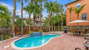 A backyard with a swimming pool, patio furniture, and a wooden fence. - Under the Tuscan Sun: *Heated Pool *Close to Beach *Perfect Central Location (Holmes Beach)