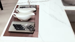 A kitchen counter with a coffee maker, water bottle, and various kitchen utensils.