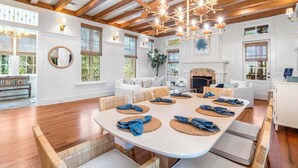 Un vaste espace dédié à la salle à manger, avec une grande table ovale pouvant accueillir six personnes, entourée de chaises en osier.