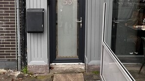 A building entrance with a glass door, a fire exit sign, and a mailbox. - 53 Luxury Rooms  (Maynooth)