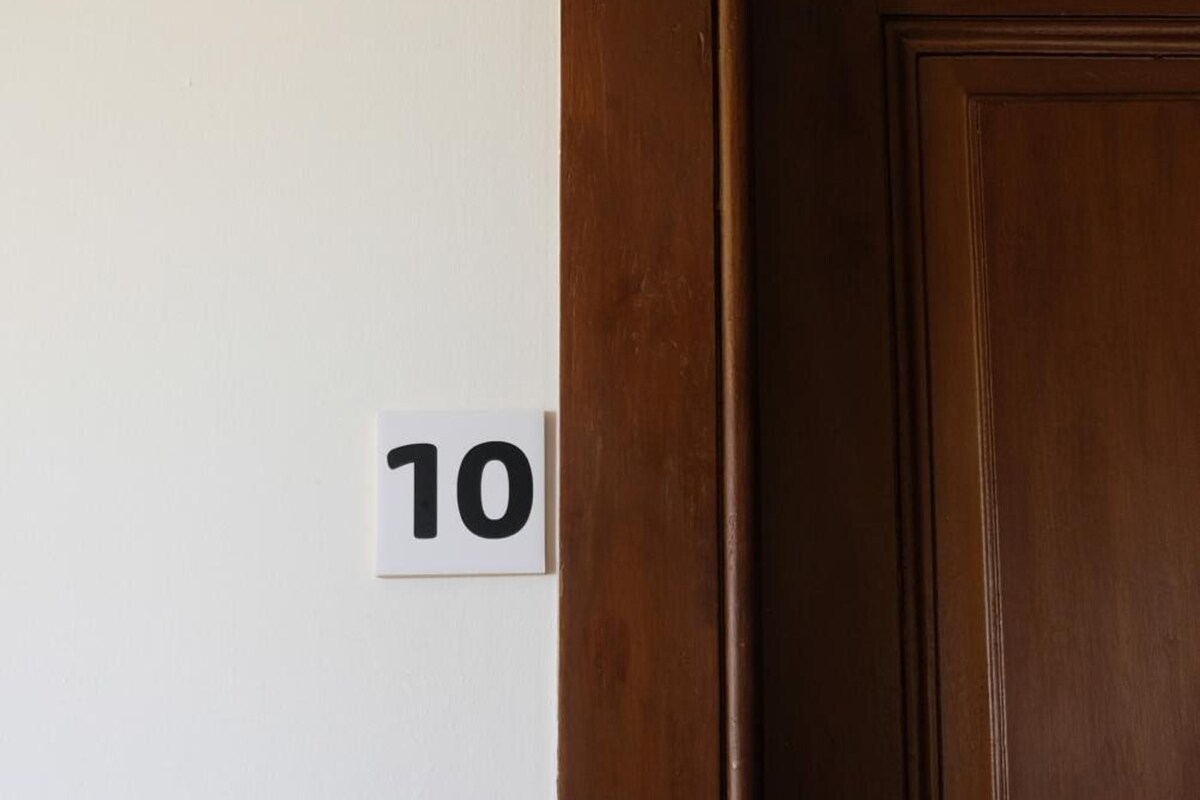 Eine Tür mit einer Holzvertäfelung und einer weißen Wand mit einem Hinweisschild.