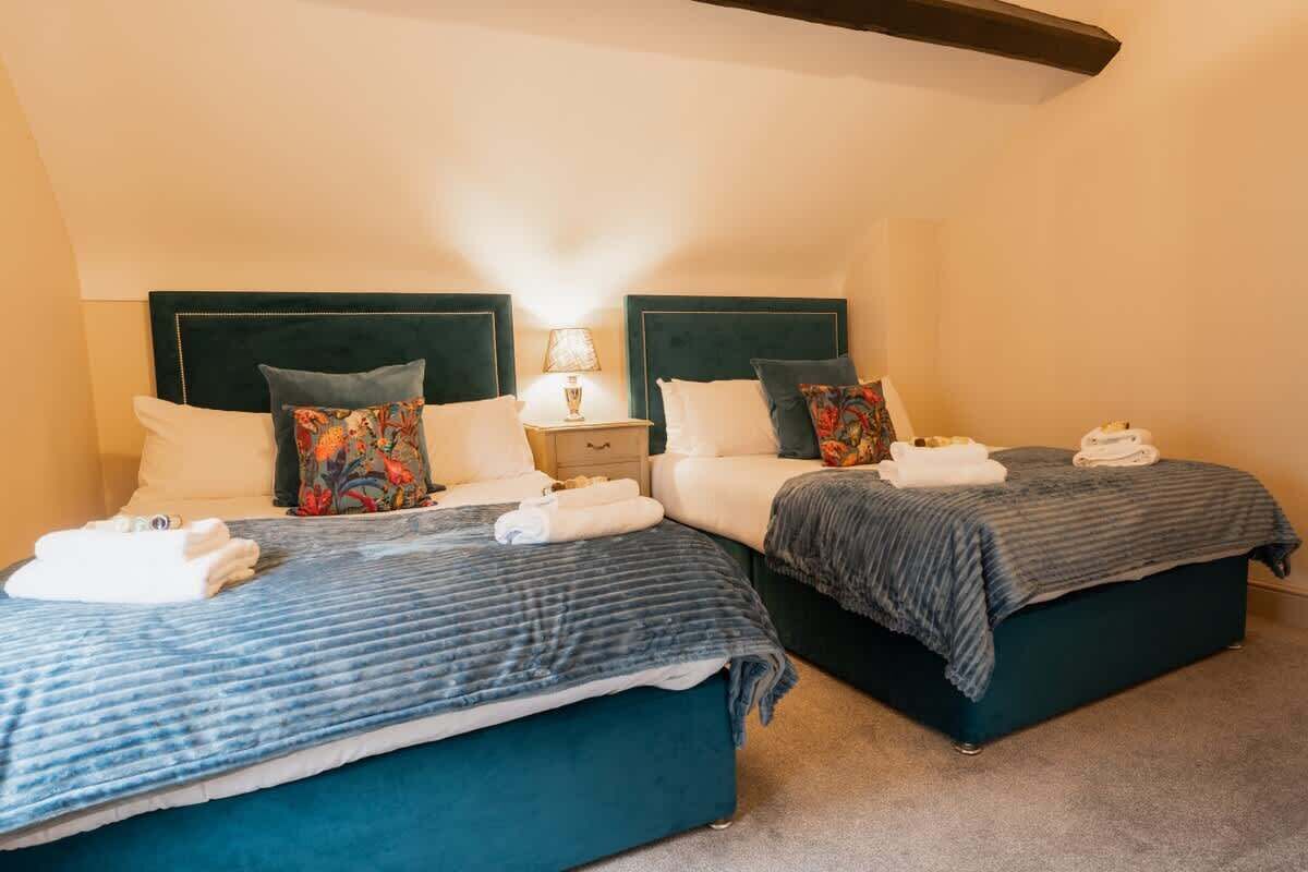 Une chambre d’hôtel avec deux lits, chacun doté d’une tête de lit, de tables de chevet et de serviettes.