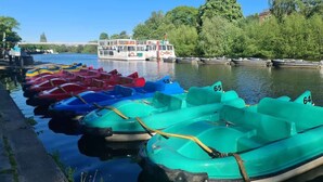 A row of numbered rowboats docked by a riverbank. - Well Decorated Home, Charming Village Location (Tarvin)
