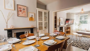 A dining area with a wooden table set for six, a fireplace, and a TV in the background. - Sleeps 6, off street parking, close to city (Cheshire West and Chester)