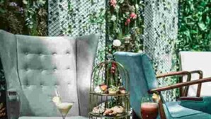 A room with a grey sofa, a round table with a drink and a tiered dessert stand, and a blue armchair. - City Hotel by Waves (Kenitra)
