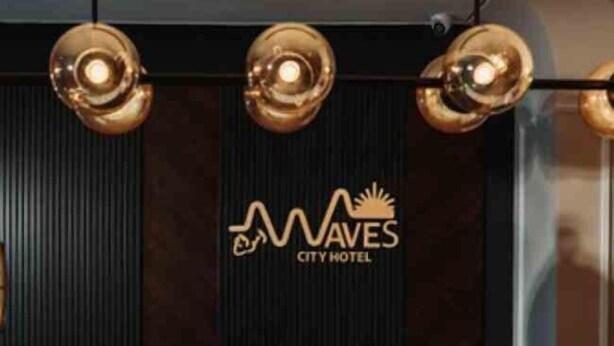 A reception desk with a logo for Waves City Hotel. - City Hotel by Waves (Kenitra)