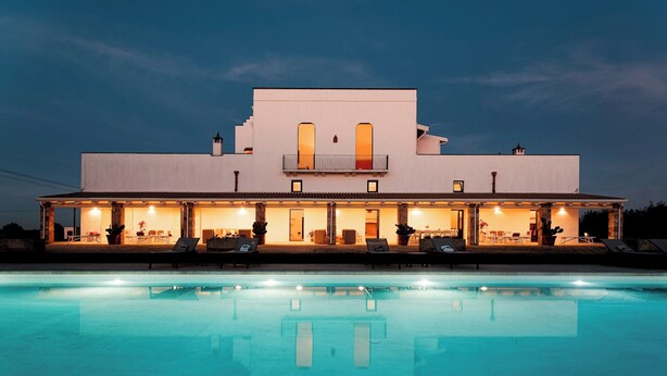 A modern two-story house with a swimming pool in front, featuring a covered patio with lounge chairs and a dining area. - Masseria Samali 14+4, Emma Villas (Leverano)