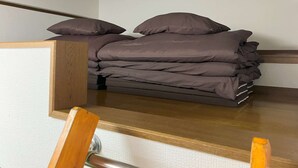 Una cama pequeña con cabecera de madera en una habitación modesta.