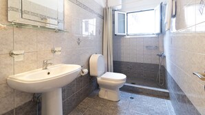 Ein Badezimmer mit Waschbecken, Toilette und Dusche.