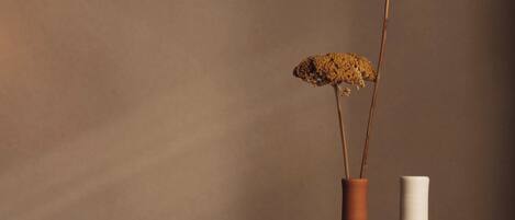 Two vases on a wooden table against a plain wall.