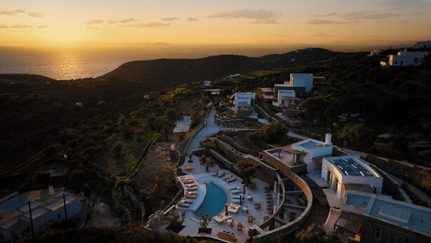 A resort with a pool, outdoor seating, and a view of the sea at sunset. - Stamna Sifnos, a member of Design Hotels (Sifnos)