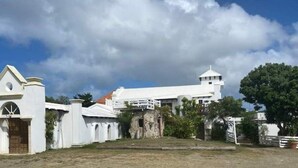 A large white building with a prominent tower and arched entrance. - The Cottage at Lowry Hill (Christiansted)