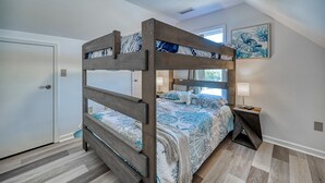 A bunk bed with a starfish decoration, a bedside lamp, and a framed artwork on the wall. - Ocean-View Retreat, Sleep 8, 6-Minute Walk to Restaurants, Pet friendly (Surf City)