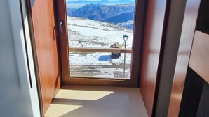 A room with a small window overlooking a snowy mountain landscape. - Habitamar El Colorado (Lo Barnechea)