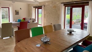 A dining area with a wooden table, colorful chairs, and a view of the outdoors.