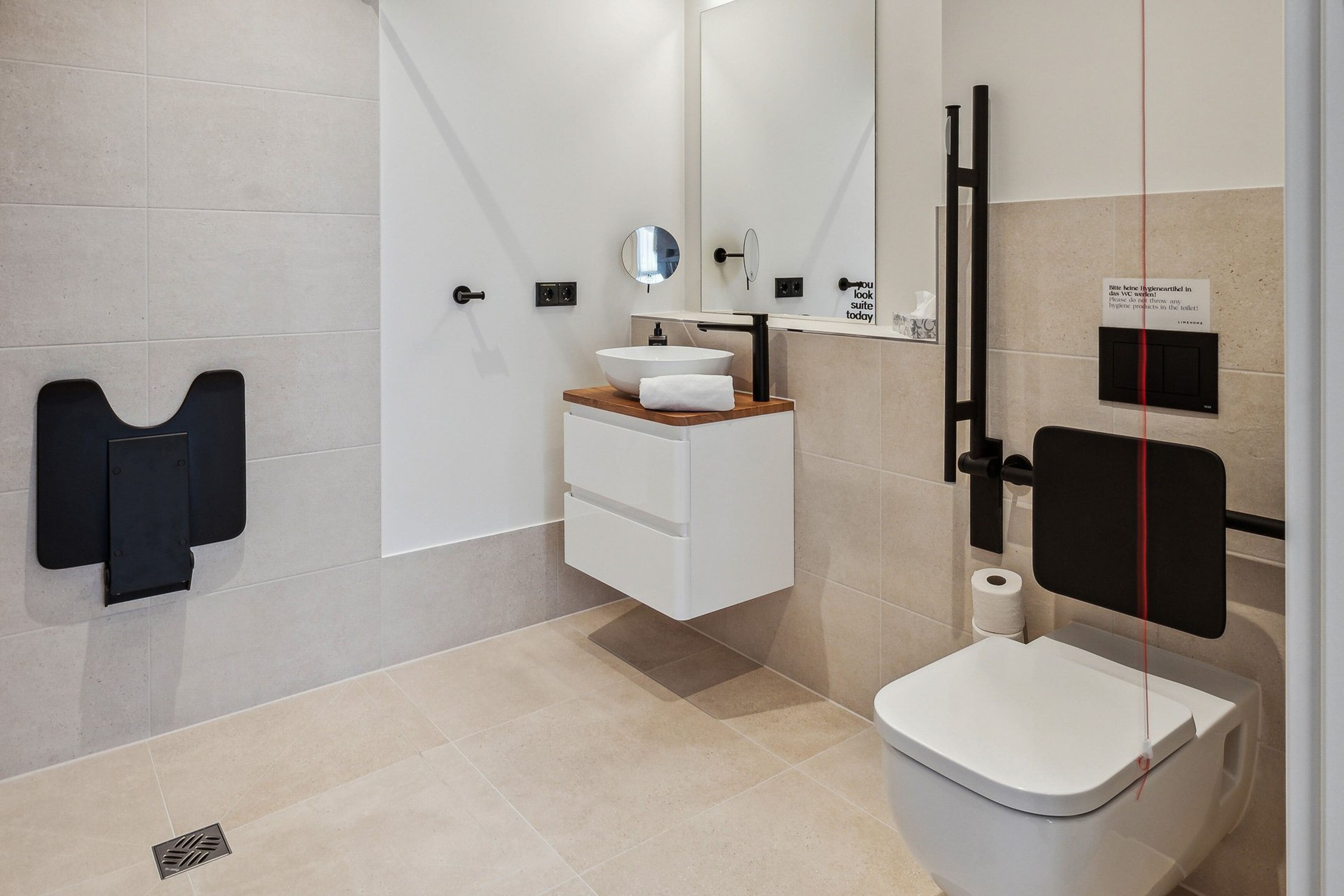 A modern bathroom with a toilet, sink, and mirror.