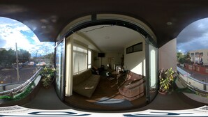 Vue panoramique d’un salon comprenant un canapé, un téléviseur et un coin repas.